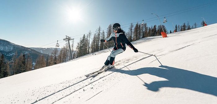 Skifahrerin bei Neuschnee auf der Spitzeckabfahrt im Skigebiet Bad Kleinkirchheim, Sonnenseite der Alpen