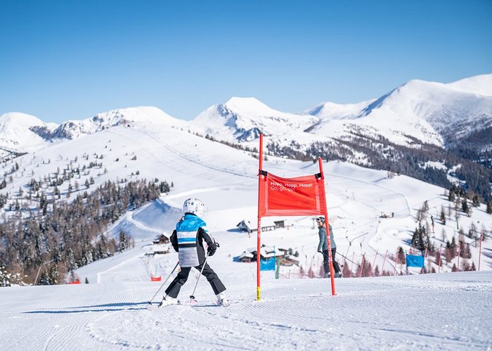 Panoramaaussicht vom Priedröf Berggipfel, Skikind bereit für die Rennstrecke, im Top Skigebiet Kärnten
