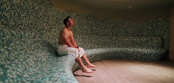 Ein Mann sitzt in der Sauna.
