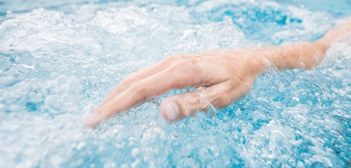 Hand im sprudelndem Thermalwasser des Thermal Römerbads