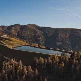 Herbstliche Drohnenaufnahme des Speicherbeckens Brunnach im Skigebiet Bad Kleinkirchheim