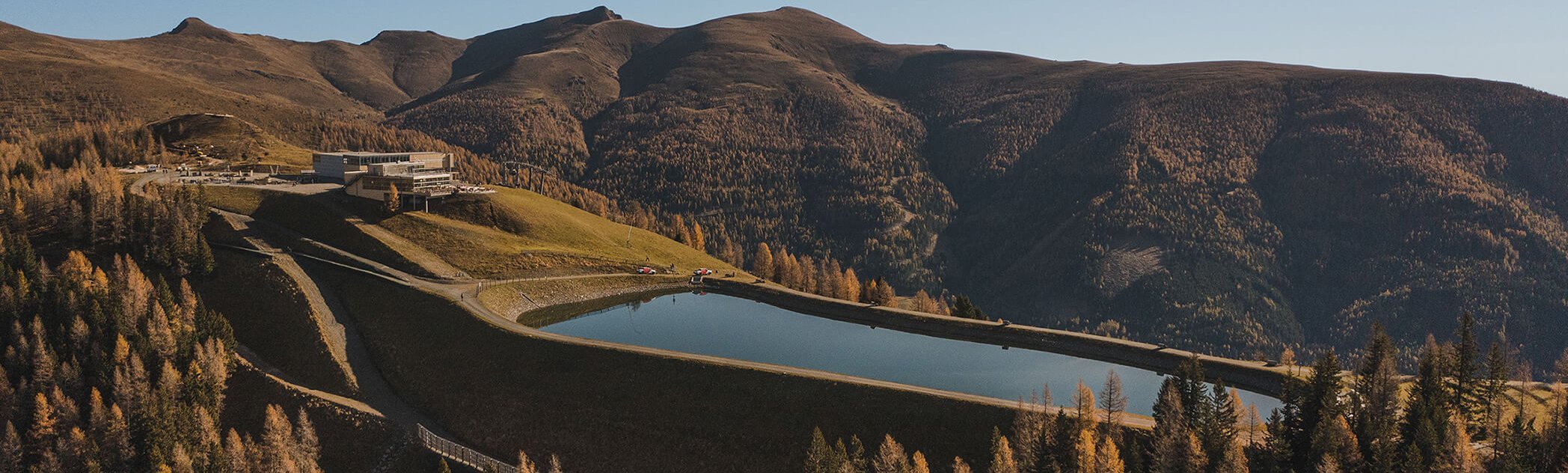 Herbstliche Drohnenaufnahme des Speicherbeckens Brunnach im Skigebiet Bad Kleinkirchheim