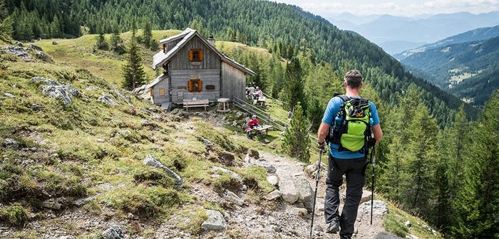 Ein Mann wandert zu einer Hütte.