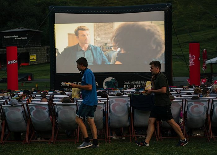 Zwei Männer, Popcorn in der Hand, schlendern am Silent Cinema entlang.