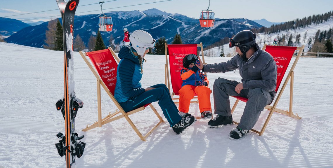 Familien an der Sonnen-Tankstelle Nockalm Bergstation in Liegestühlen