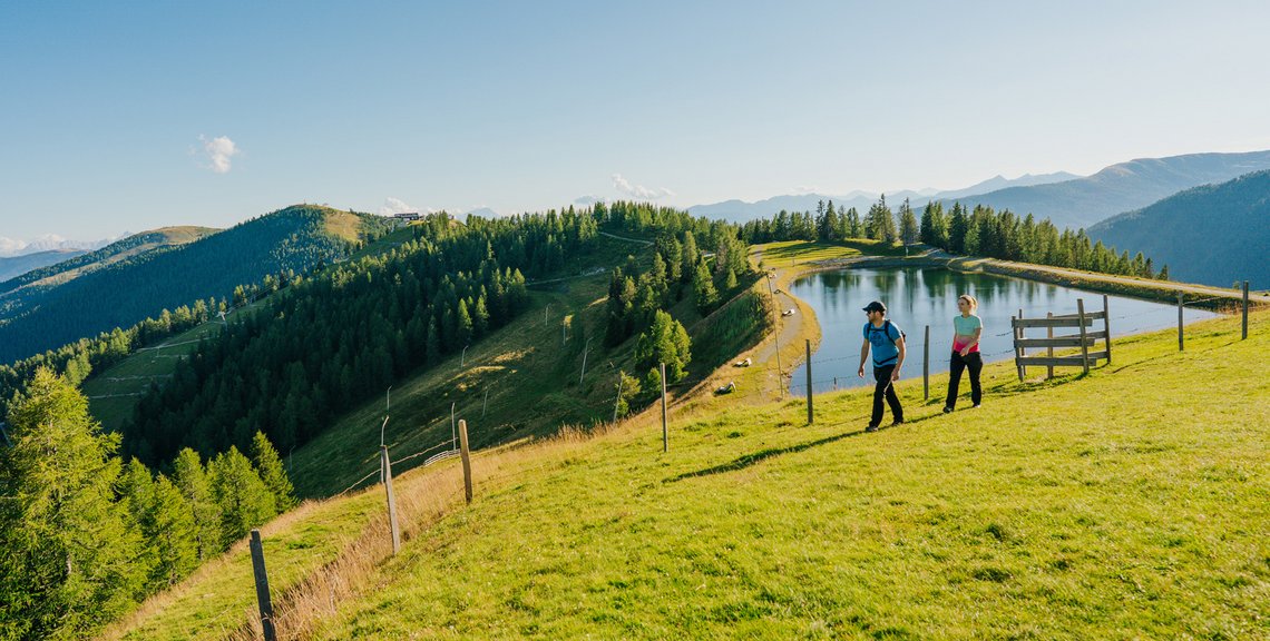 Speichersee Brunnach im Sommer, Wanderpärchen im UNESCO Biosphärenpark Kärntner Nockberge