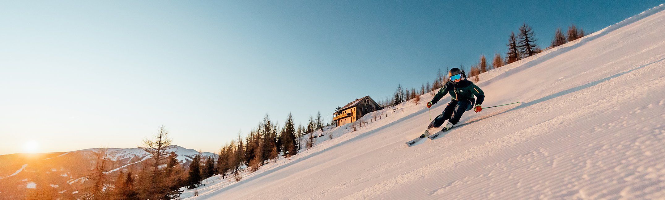 Sonnenaufgang in Bad Kleinkirchheim im Winter, Skifahrer auf Priedröfabfahrt, Nockberge Panorama in den österreichischen Alpen