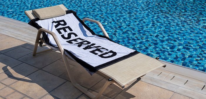 Auf einer Liege liegt ein Handtuch mit den Wort 'Reserved'.