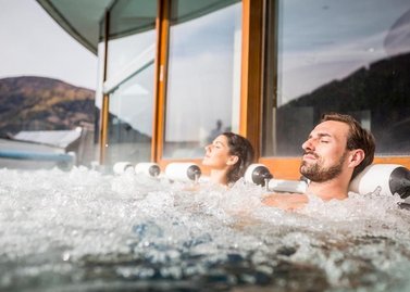 Relaxen auf der Sonnenterrasse im Thermal Römerbad in Bad Kleinkirchheim, Sprudelliegen mit Panorama-Aussicht, Panoramabecken in einer der größten Thermen Kärnten