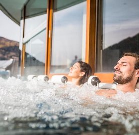 Relaxen auf der Sonnenterrasse im Thermal Römerbad in Bad Kleinkirchheim, Sprudelliegen mit Panorama-Aussicht, Panoramabecken in einer der größten Thermen Kärnten