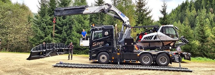 Lieferung des neuen Pistengeräts via LKW, Abladen mit einem LKW-Kran, 530 PS Maschine, modern und effizient für den Ski-Winter