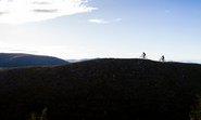 Zwei Mountainbiker fahren durch eine atemberaubende Berglandschaft.