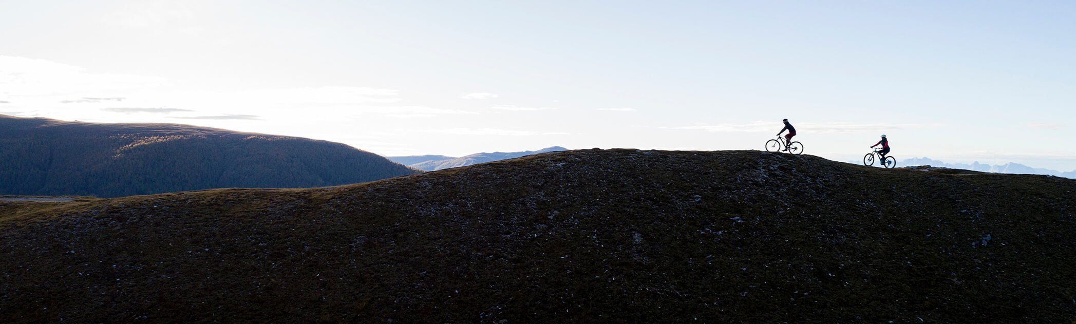 Zwei Mountainbiker fahren durch eine atemberaubende Berglandschaft.