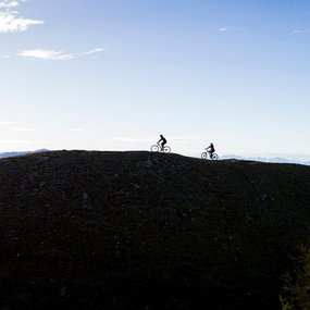 Zwei Mountainbiker fahren durch eine atemberaubende Berglandschaft.