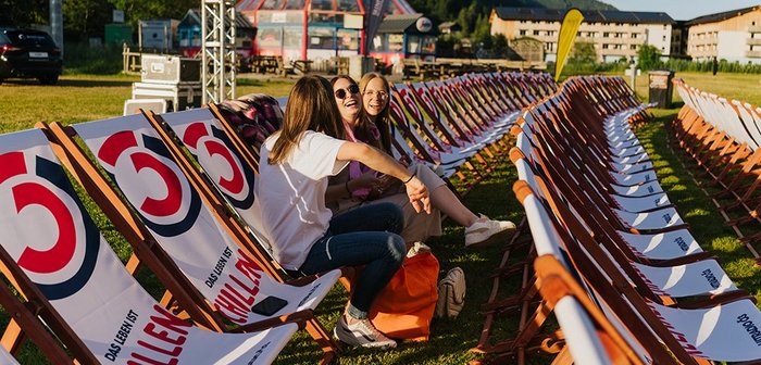 Drei Frauen sitzen auf Liegestühlen und unterhalten sich.