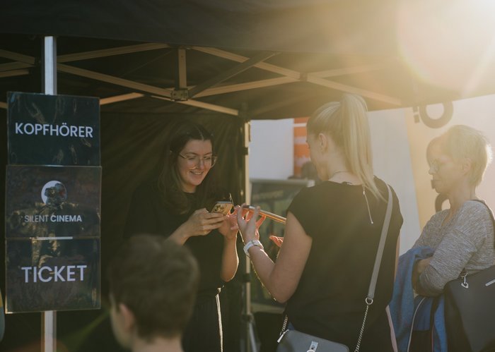 Drei Frauen stehen am Ticketstand fürs Silent Cinema.