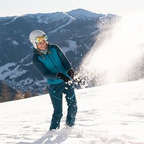 Ein Mann und eine Frau und ein Kind machen eine Schneeballschlacht.