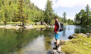 Ein Mann mit Sonnenbrille steht an einem See.