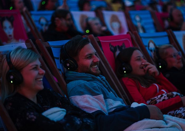 Ein Mann und zwei Frauen lachen beim Silent Cinema.