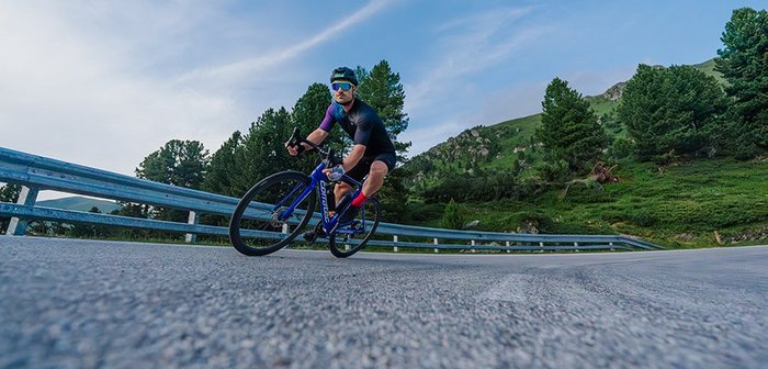 Ein Radfahrer rast zügig die Straße entlang.