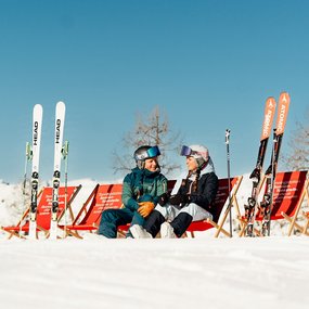 Junges Paar bei den Sonnentankstellen im Skigebiet Bad Kleinkirchheim, Top Winter-Aussicht in den österreichischen Alpen, Pause mit Panorama