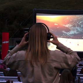 Eine Frau setzt sich ihre Kopfhörer fürs Silent Cinema auf.