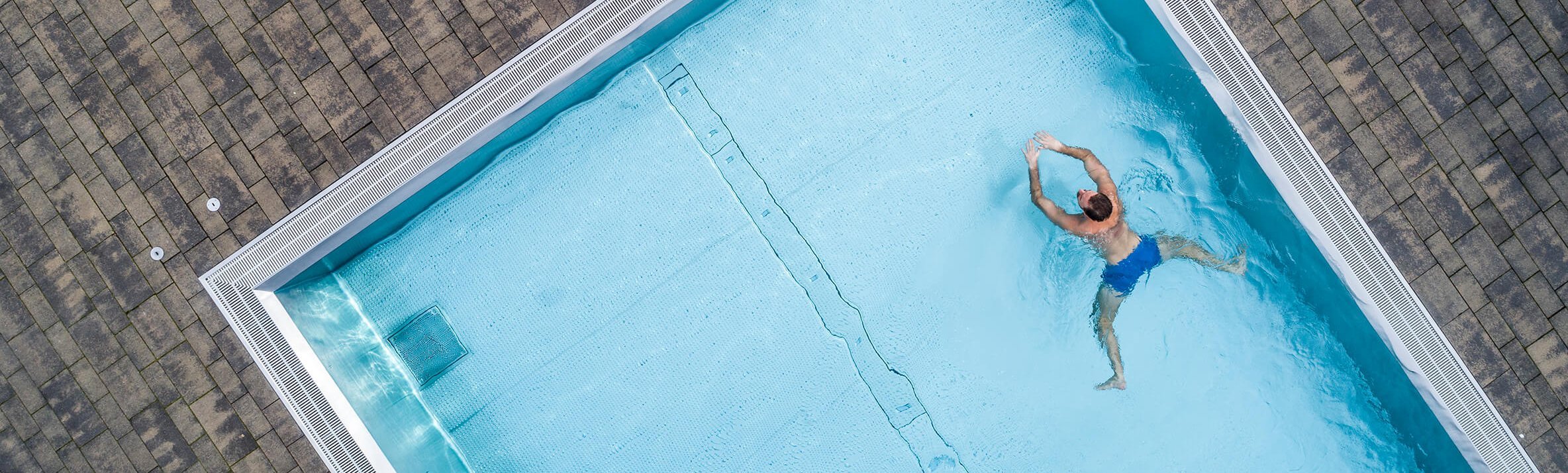 Ein Mann schwimmt in einem Pool.