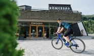 Ein Radfahrer fährt vor dem Römerbad entlang.