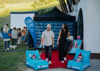 Open-Air-Kino in Tirol: Mann und Frau auf rotem Teppich vor Leinwand und Sponsorenwand