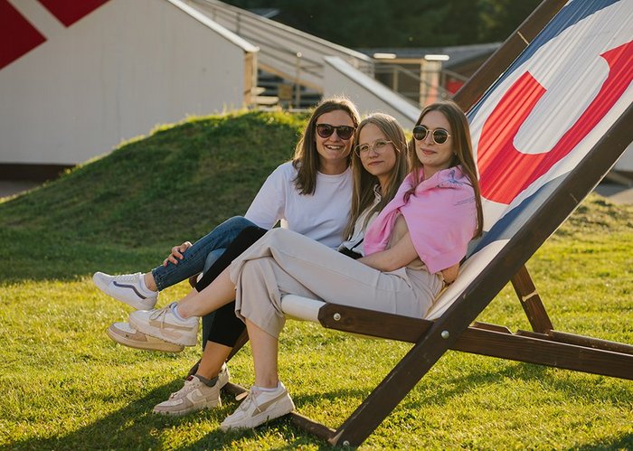 Drei Frauen sitzen zusammen auf einem riesigen Liegestuhl.