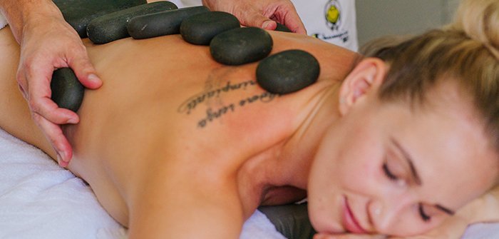 Hot-Stone-Massage im Bad Kleinkirchheimer Thermal Römerbad, Frau genießt Massage-Angebot, entspannte Auszeit in Kärnten beim Wellnesstag
