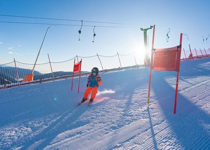 Kind auf Rennstrecke im Skigebiet Bad Kleinkirchheim, Pistenspaß für Groß und Klein, Top Familienregion in Kärnten