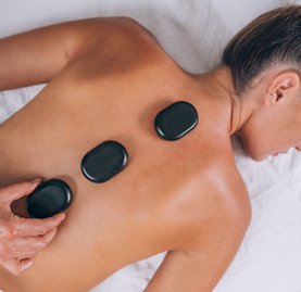 Frau bei einer Hot Stone Massage im Thermal Römerbad in Bad Kleinkirchheim