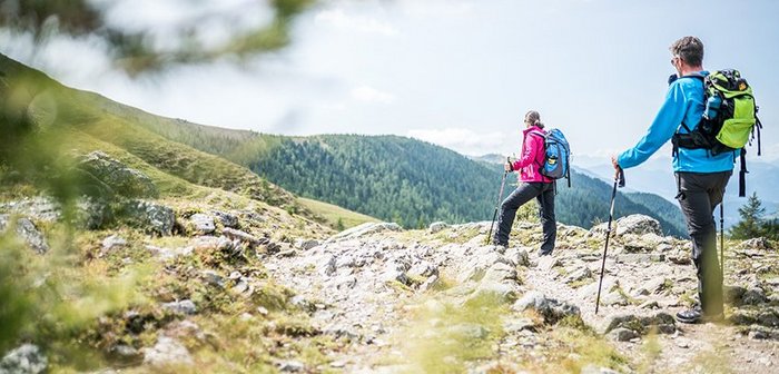 Zwei Wanderer blicken auf eine traumhafte Berglandschaft.