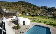 Sommeratmosphäre im Outdoor-Saunabereich mit Pool, im Außenbereich des Bad Kleinkirchheimer Thermal Römerbads