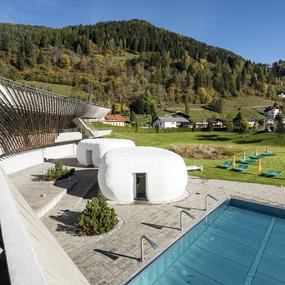 Sommeratmosphäre im Outdoor-Saunabereich mit Pool, im Außenbereich des Bad Kleinkirchheimer Thermal Römerbads